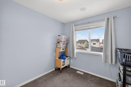 This room features a window providing natural light, light blue walls, and a textured ceiling - 1522 Chapman Way, Edmonton, AB - Indoor