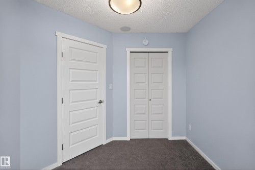 Room featuring light blue walls, dark gray carpet, a white ceiling, and white trim - 1522 Chapman Way, Edmonton, AB - Indoor