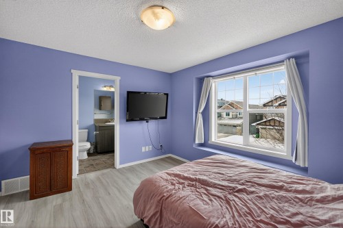 This room features light-toned flooring, a window with white trim, and a ceiling light fixture - 1522 Chapman Way, Edmonton, AB - Indoor Photo Showing Bedroom