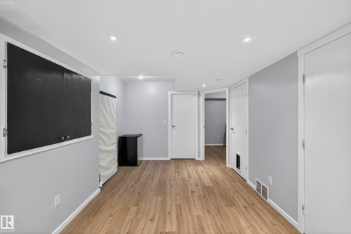 The property features light wood flooring, white trim, and light grey walls - 1522 Chapman Way, Edmonton, AB - Indoor Photo Showing Other Room