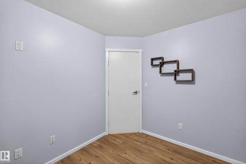This room features light blue walls, a white ceiling, and wood-style flooring - 1522 Chapman Way, Edmonton, AB - Indoor Photo Showing Other Room