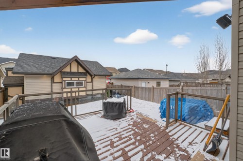 The property includes a spacious wood deck with glass panel railings, overlooking a fenced yard - 1522 Chapman Way, Edmonton, AB - Outdoor With Exterior