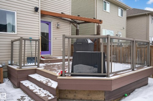 The property features a multi-level deck with glass panel railings and a pergola - 1522 Chapman Way, Edmonton, AB - Outdoor With Exterior