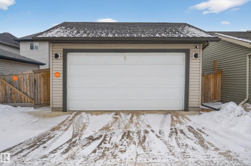 The property features a garage with a white overhead door and siding exterior - 1522 Chapman Way, Edmonton, AB - Outdoor With Exterior