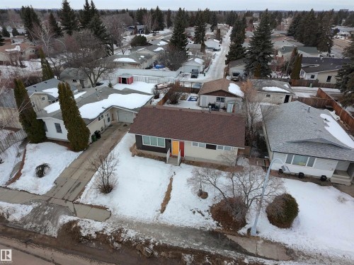 The property features a brown shingle roof and a light-colored exterior with a red front door - 3912 108 Street, Edmonton, AB - Outdoor