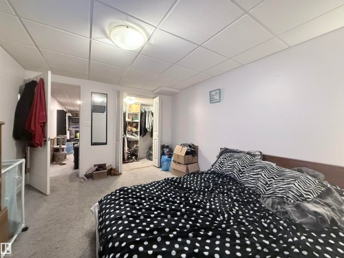This room features carpeted flooring and white walls, complemented by a drop ceiling with an overhead light fixture - 3912 108 Street, Edmonton, AB - Indoor Photo Showing Bedroom