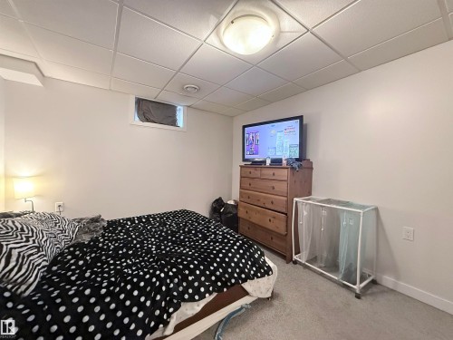 This room features a neutral wall color, light-colored carpet, and a drop ceiling - 3912 108 Street, Edmonton, AB - Indoor Photo Showing Bedroom