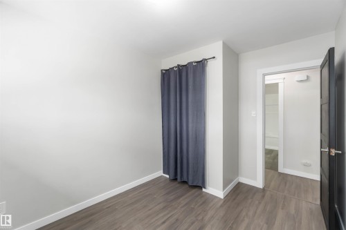 Room featuring wood-look flooring, light gray walls, and white trim - 12121 38 Street, Edmonton, AB - Indoor Photo Showing Other Room