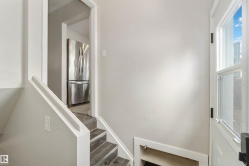This area features a staircase with solid treads and a white railing, leading to an interior space - 12121 38 Street, Edmonton, AB - Indoor Photo Showing Other Room