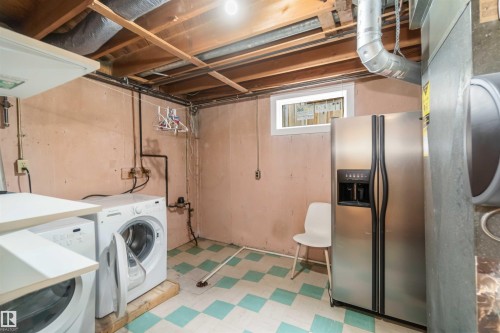 Utility room with a washing machine, dryer, and a stainless steel refrigerator - 12121 38 Street, Edmonton, AB - Indoor Photo Showing Laundry Room