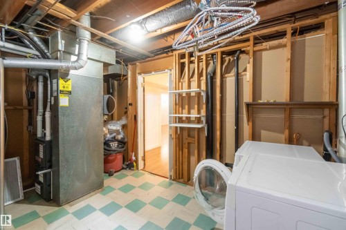 The property features a utility area with a washer and dryer, a furnace, and a tiled floor - 12121 38 Street, Edmonton, AB - Indoor