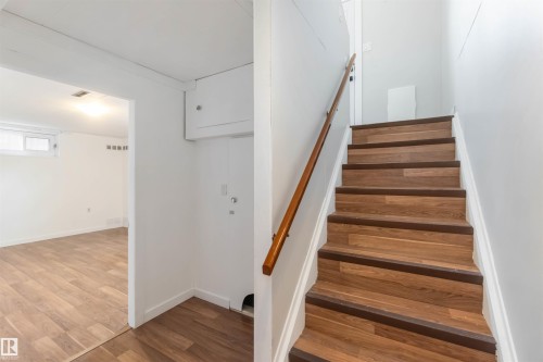 Staircase featuring wood-look treads with dark risers and a wooden handrail - 12121 38 Street, Edmonton, AB - Indoor Photo Showing Other Room