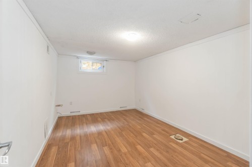 The room features wood-style flooring and a window providing natural light - 12121 38 Street, Edmonton, AB - Indoor Photo Showing Other Room