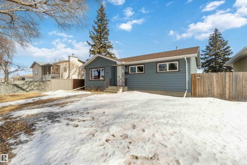 This property features a blue exterior, a brown roof, and multiple visible windows - 12121 38 Street, Edmonton, AB - Outdoor