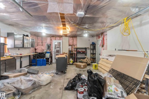 The property features a utility space with exposed insulation, a concrete floor, and overhead lighting - 12121 38 Street, Edmonton, AB - Indoor Photo Showing Basement