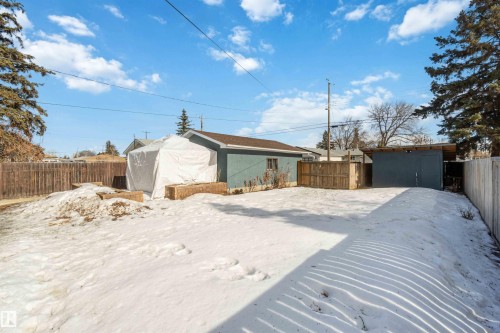 The property features a spacious yard with a wooden fence and a detached shed - 12121 38 Street, Edmonton, AB - Outdoor