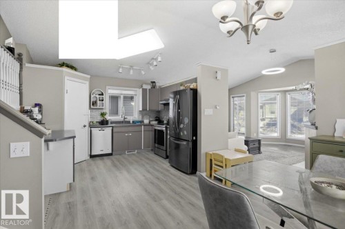 The kitchen features gray cabinetry, a tile backsplash, and a window above the sink - 5837 162A Avenue, Edmonton, AB - Indoor Photo Showing Kitchen