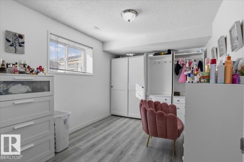 This room features light-colored laminate flooring, a window with blinds, and white walls - 5837 162A Avenue, Edmonton, AB - Indoor