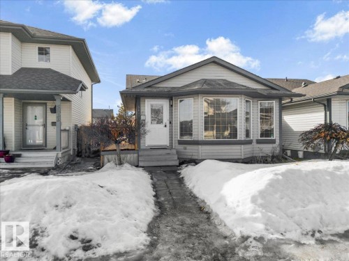 This property features a front entrance with a small porch and steps, a bay window, and light-colored siding - 5837 162A Avenue, Edmonton, AB - Outdoor With Facade