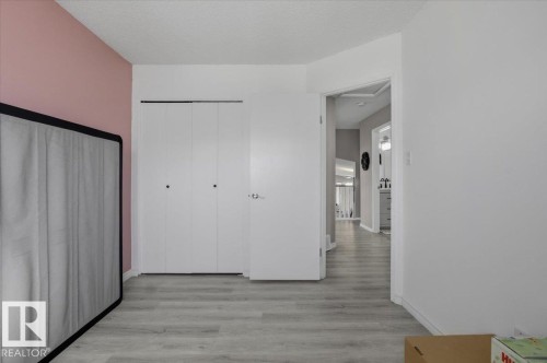 This room features light grey flooring, white walls, and a closet with bi-fold doors - 5837 162A Avenue, Edmonton, AB - Indoor Photo Showing Other Room
