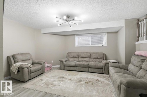 Living area featuring light grey walls, a window with blinds, and light-colored flooring - 5837 162A Avenue, Edmonton, AB - Indoor