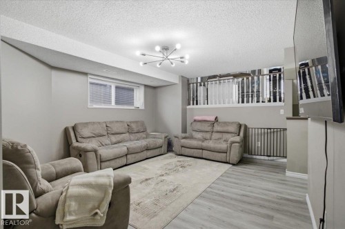 The living area features light grey walls, light-colored flooring, and a contemporary ceiling light fixture - 5837 162A Avenue, Edmonton, AB - Indoor
