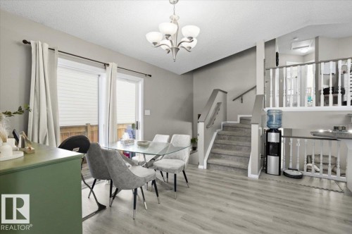 The interior features light gray walls, light wood-look flooring, and a chandelier - 5837 162A Avenue, Edmonton, AB - Indoor Photo Showing Dining Room