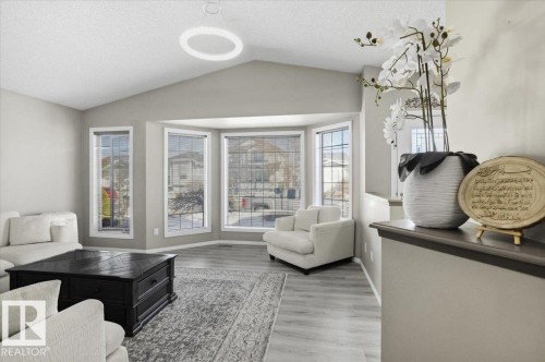 Living area featuring vaulted ceilings, light-colored walls, and large bay windows providing natural light - 5837 162A Avenue, Edmonton, AB - Indoor Photo Showing Living Room