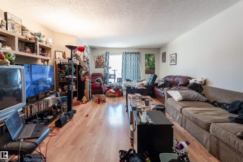 Living area featuring light wood flooring and light-colored walls, providing a neutral canvas - 2 10737 116 Street, Edmonton, AB - Indoor Photo Showing Living Room
