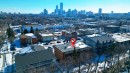 This property features a brick exterior and a dark-colored roof, surrounded by paved areas and trees - 2 10737 116 Street, Edmonton, AB  - Outdoor With View 