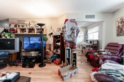 This living area features light-colored flooring and a television display - 2 10737 116 Street, Edmonton, AB - Indoor