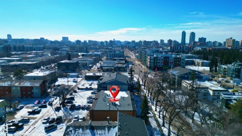 Aerial view of the property and its surrounding urban landscape, featuring various buildings, roads, and a visible skyline in the background - 2 10737 116 Street, Edmonton, AB - Outdoor With View