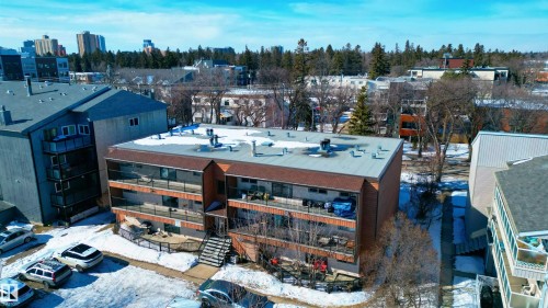 The property features a multi-story building with balconies, a flat roof, and an exterior of brick and horizontal siding - 2 10737 116 Street, Edmonton, AB - Outdoor
