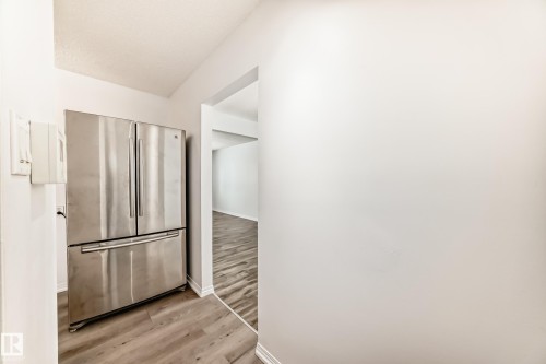 The property features a stainless steel refrigerator with a bottom freezer drawer and french doors - 4312 43 Avenue, Leduc, AB - Indoor
