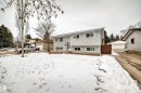The property features a light gray exterior with white trim, a front yard, and a driveway leading to a detached garage - 4312 43 Avenue, Leduc, AB  - Outdoor 