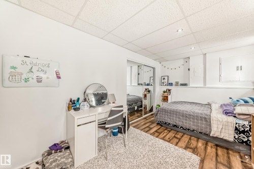 This room features white walls, a drop ceiling with recessed lighting, and wood-style flooring - 4312 43 Avenue, Leduc, AB - Indoor Photo Showing Bedroom