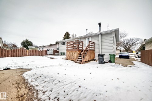 The property features a wooden deck with stairs, a light-colored siding exterior, and a fenced yard - 4312 43 Avenue, Leduc, AB - Outdoor With Exterior