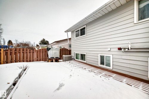 The property features light gray siding with white trim around the windows and a brown slatted wooden deck - 4312 43 Avenue, Leduc, AB - Outdoor With Exterior