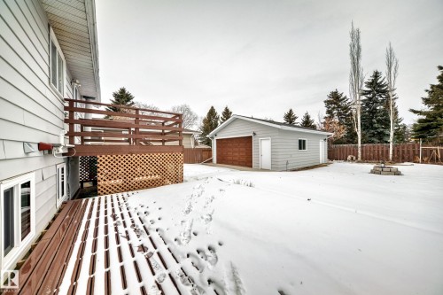 The property features a spacious yard with mature trees and a detached garage - 4312 43 Avenue, Leduc, AB - Outdoor With Deck Patio Veranda