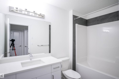 Bathroom featuring vanity, shower / bath combination, and a textured ceiling - 53 7110 Keswick Common Sw, Edmonton, AB - Indoor Photo Showing Bathroom