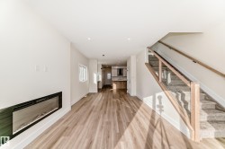 This open concept living area features light-toned flooring, a sleek fireplace, and recessed lighting - 