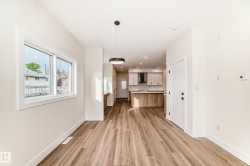 The property features plank flooring and a modern light fixture, with a window providing exterior views - 