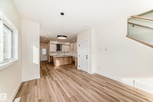 The property features light wood flooring, white walls, and a modern kitchen with light wood cabinetry and white countertops - 10718 149 Street Nw, Edmonton, AB - Indoor