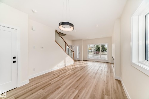 The interior features light wood flooring, white walls, and a modern light fixture - 10718 149 Street Nw, Edmonton, AB - Indoor Photo Showing Other Room
