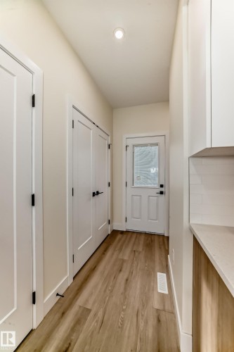 The property features a bright hallway with light-toned walls and wood-look flooring - 10718 149 Street Nw, Edmonton, AB - Indoor Photo Showing Other Room