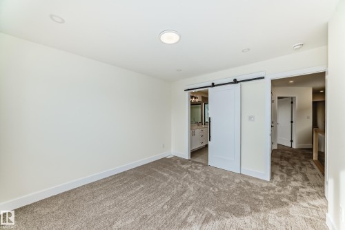 Carpeted room with recessed lighting and a white barn door - 10718 149 Street Nw, Edmonton, AB - Indoor Photo Showing Other Room