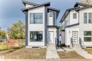 Modern two-story property featuring a distinctive angular roofline, a white and charcoal grey exterior, and a contemporary entry door with a privacy window - 10718 149 Street Nw, Edmonton, AB  - Outdoor With Facade 