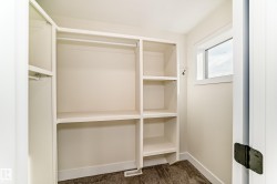 Closet with built-in shelving, hanging rods, and a window for natural light - 