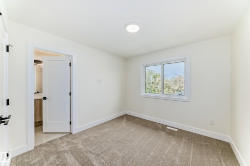 This room features plush grey carpeting, white walls, and a window providing natural light - 10718 149 Street Nw, Edmonton, AB - Indoor Photo Showing Other Room