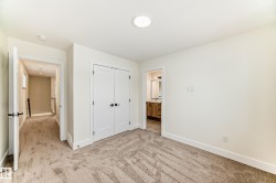 This room features neutral-toned carpet flooring and white walls, complemented by white trim and doors - 